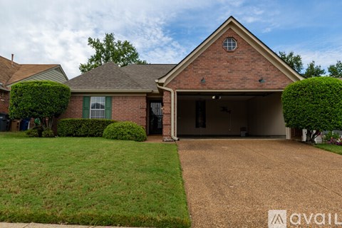 A house with a brick exterior and a large driveway.