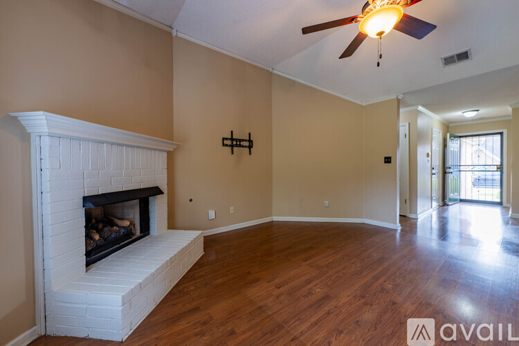 A living room with a fireplace and a ceiling fan.