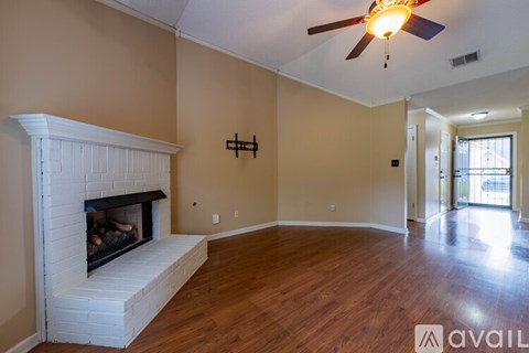 A living room with a fireplace and a ceiling fan.