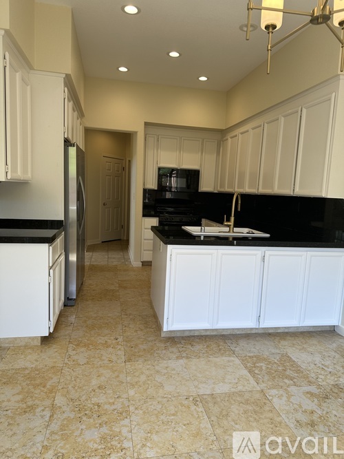A kitchen with black countertops and white cabinets.
