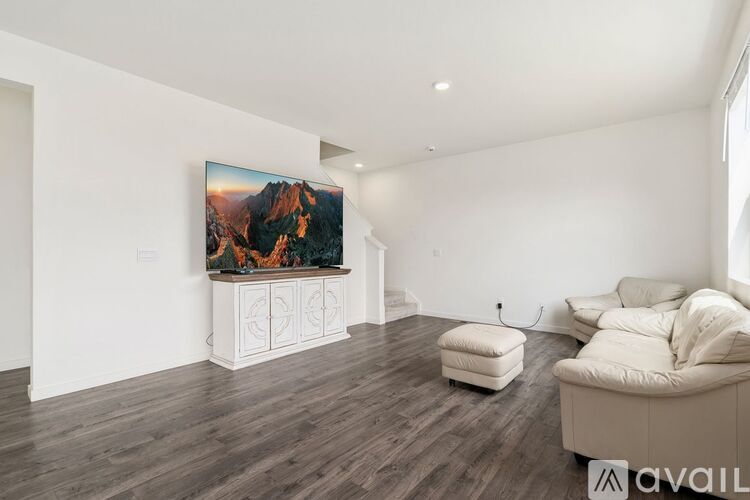 A living room with a large painting on the wall and a white sofa.