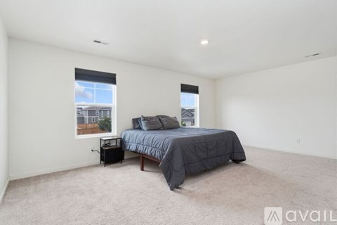 A bedroom with a bed, nightstand, and window.