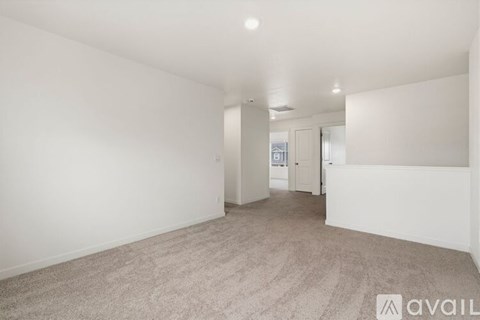 A spacious room with carpeted floor and white walls.