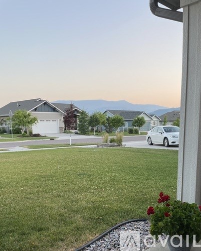 A white car is parked in a driveway.