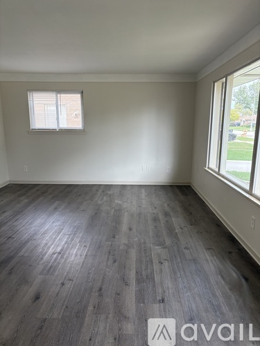 A room with wooden flooring and a window.
