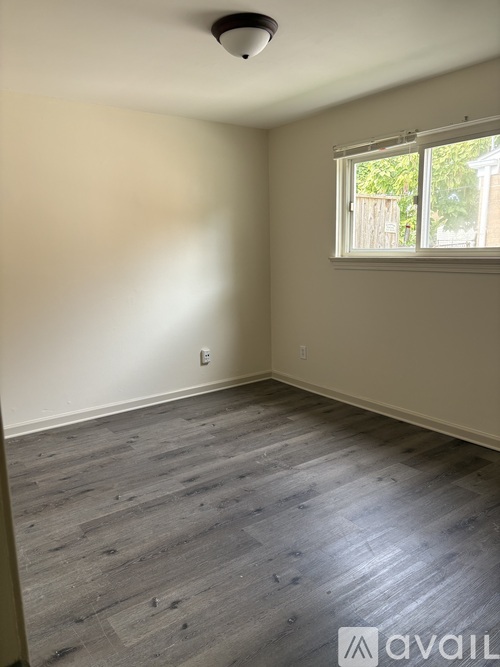 A room with a window and wooden flooring.
