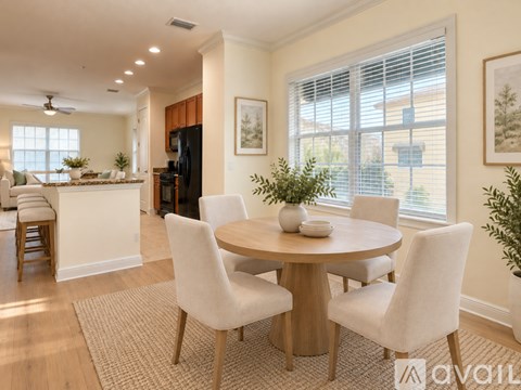 A dining room with a round table and chairs.