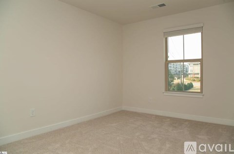 A room with a window and a view of a building outside.