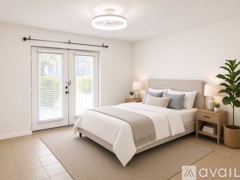 A bedroom with a large bed, a window with blinds, and a plant on the side table.