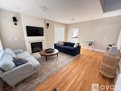 A living room with a grey couch, a coffee table, and a fireplace.