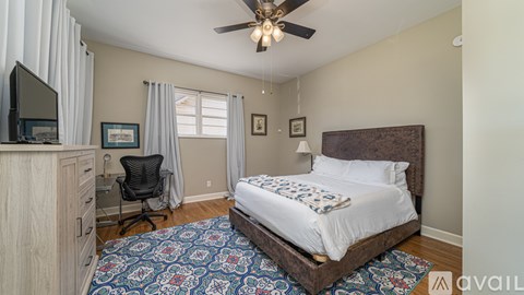 A bedroom with a large bed and a ceiling fan.