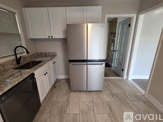 A kitchen with a white fridge and a black dishwasher.