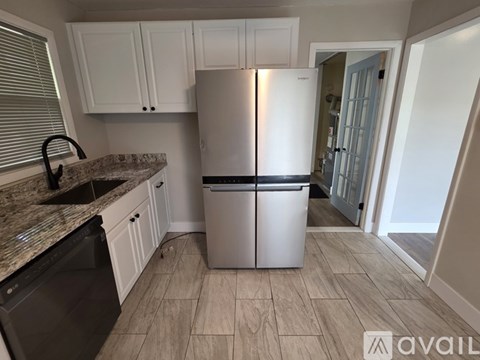 A kitchen with a white fridge and a black dishwasher.