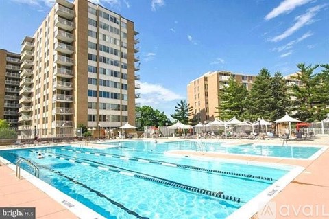 A large swimming pool in front of apartment buildings.