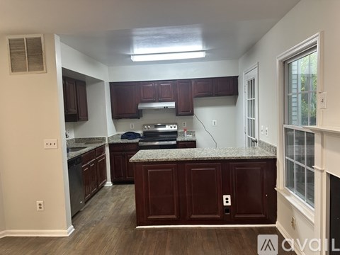 A kitchen with brown cabinets and a granite countertop.