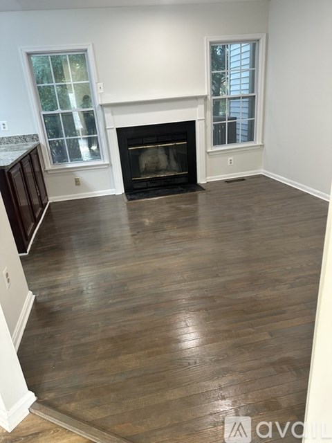 A living room with a fireplace and wood flooring.
