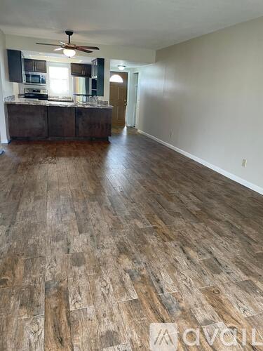 A room with wooden flooring and a ceiling fan.