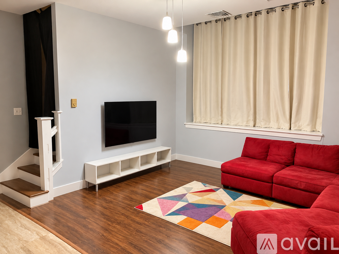 A living room with a red couch and a television.