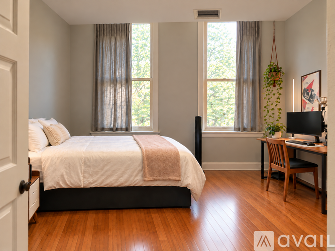 A bedroom with a large bed and a desk with a chair.