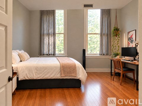 A bedroom with a large bed and a desk with a chair.