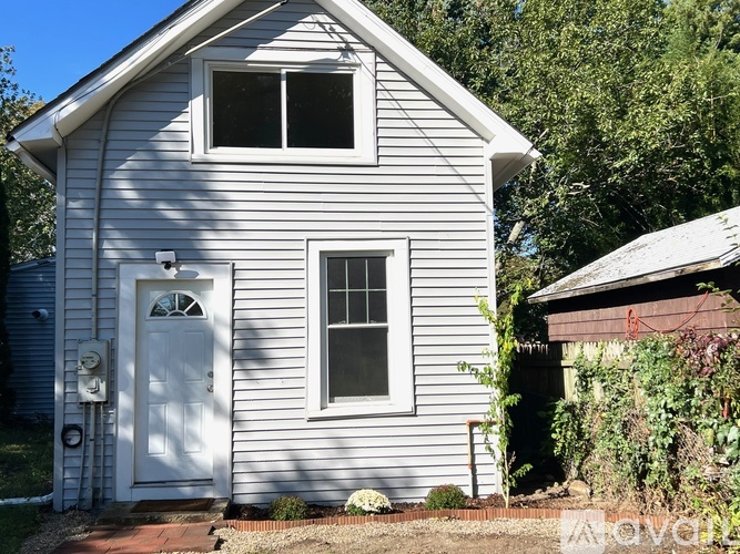 A small white house with a door and a window.