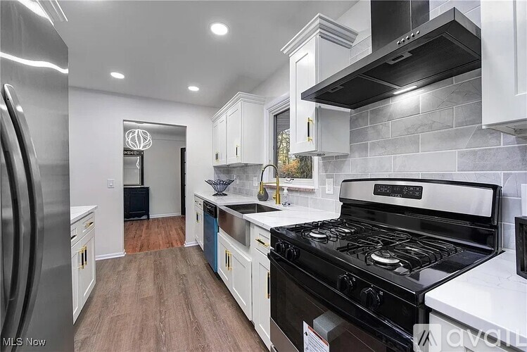 A kitchen with a black stove top oven and white cabinets.