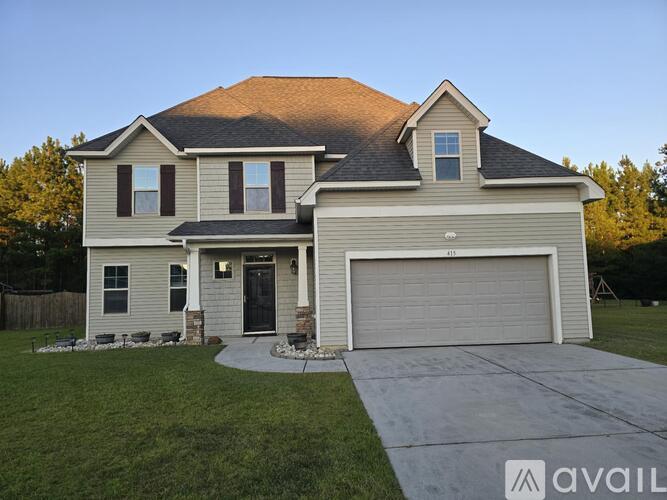 A two-story house with a garage is available for sale.