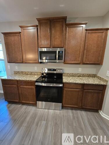 A kitchen with wooden cabinets and a black stove top oven.