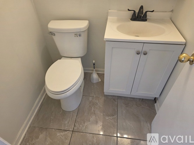 A white toilet and sink in a bathroom.