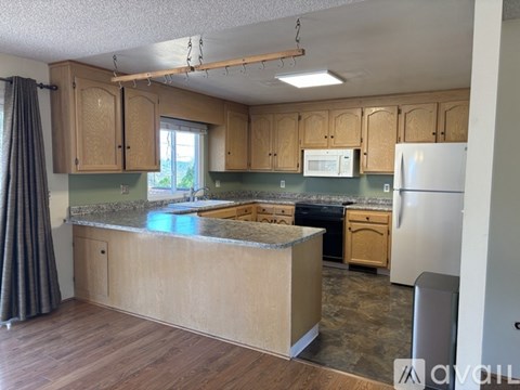 A kitchen with wooden cabinets and a granite countertop.