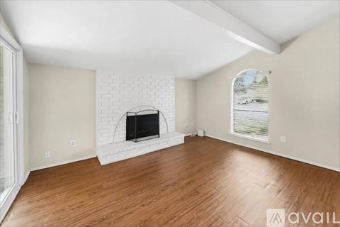 A room with a fireplace and wooden floors.