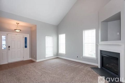 A living room with a fireplace and a door on the left.