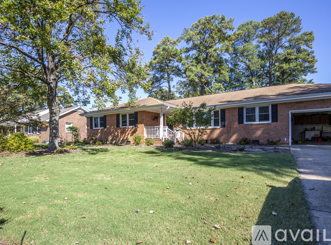 A house with a lawn and trees in the background.