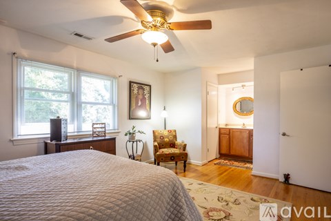 A bedroom with a large bed and a ceiling fan.
