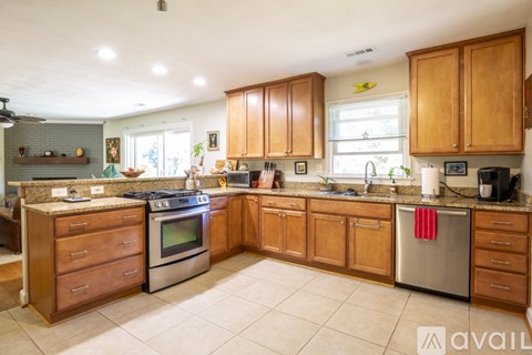 A kitchen with wooden cabinets and a stainless steel refrigerator.