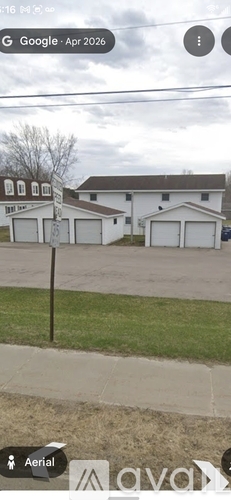 A white house with a brown roof and a garage door.