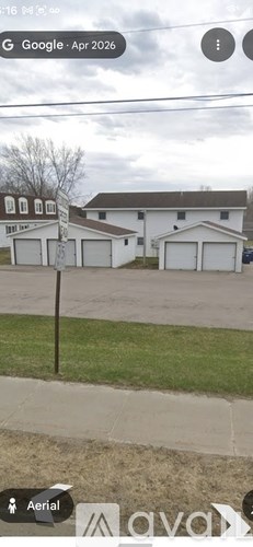 A white house with a brown roof and a garage door.