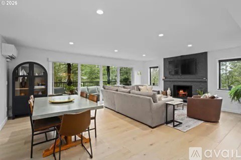 A modern living room with a fireplace and a dining table.