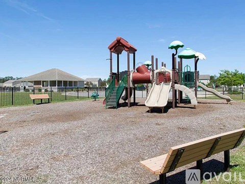 A playground with a slide, swings, and a bench.