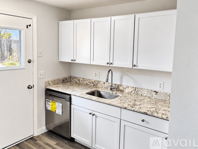 A kitchen with white cabinets and a granite countertop.