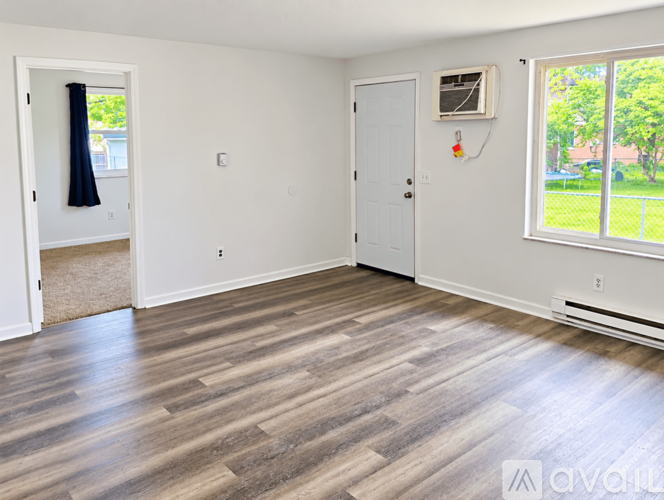 A room with wooden flooring and white walls.