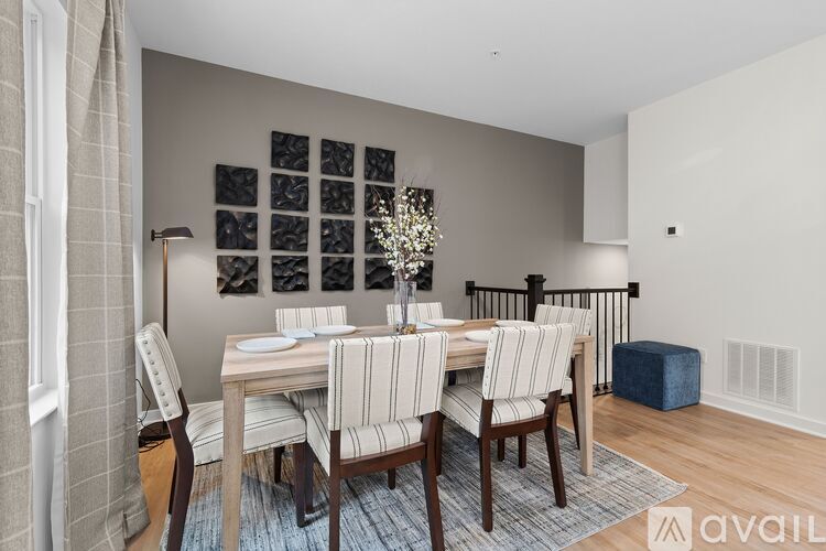 A dining room with a wooden table and chairs.