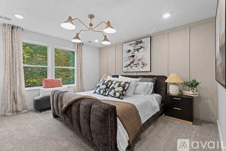 A bedroom with a large bed and a chandelier.
