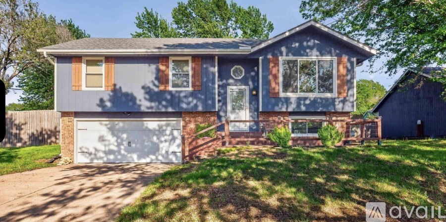 A blue house with a white garage door and a brown door.