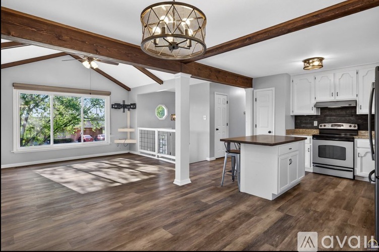 A kitchen with white cabinets and a wooden floor.