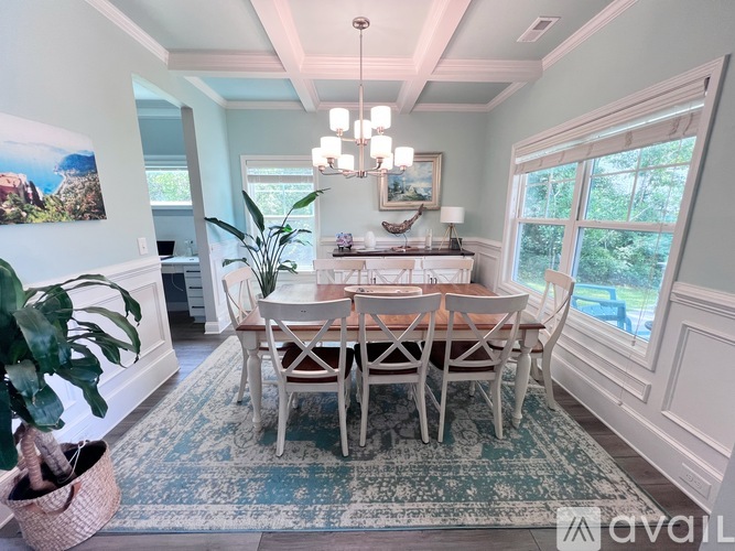 A dining room with a large table and chairs.