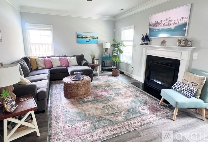 A living room with a fireplace and a large painting above it.