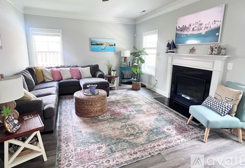 A living room with a fireplace and a large painting above it.