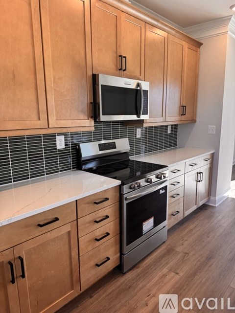 A kitchen with wooden cabinets and a black stove top oven.