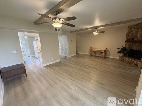 A spacious room with a ceiling fan and lighting fixture.